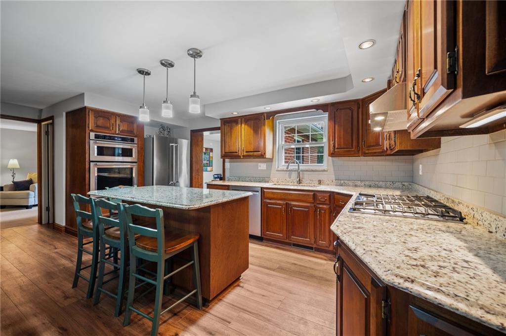 2387 Harrison City Road Export, PA 15632 - Photo 12 of 48 a kitchen with stainless steel appliances granite countertop a stove a sink and a wooden floors