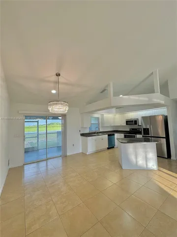 a large kitchen with stainless steel appliances a stove a sink and a refrigerator