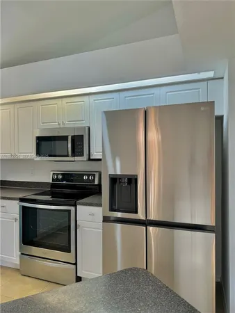 a kitchen with stainless steel appliances a refrigerator stove and microwave