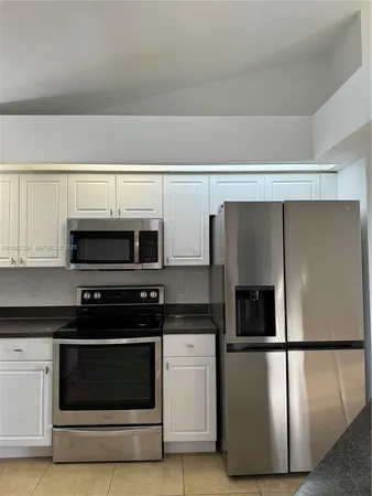 a kitchen with stainless steel appliances a refrigerator stove and microwave