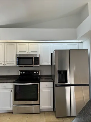 a kitchen with stainless steel appliances a refrigerator stove and microwave