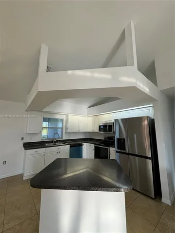 a kitchen with stainless steel appliances granite countertop a sink and a stove
