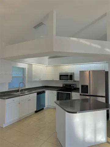 a kitchen with stainless steel appliances granite countertop a sink and a refrigerator