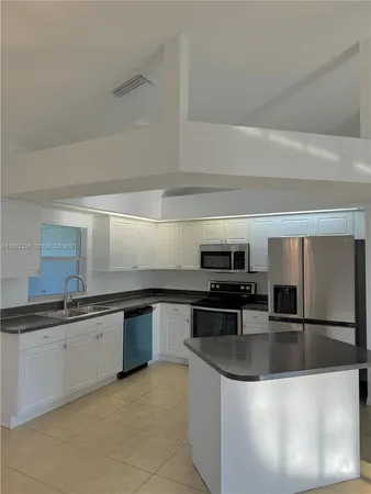 a kitchen with stainless steel appliances granite countertop a sink and a refrigerator