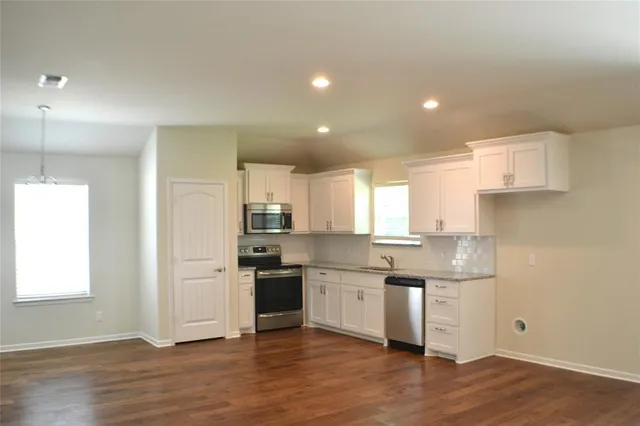 a kitchen with stainless steel appliances granite countertop a sink and a refrigerator