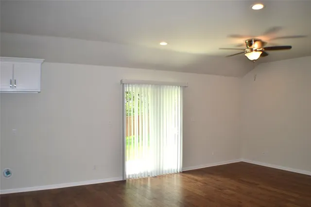 an empty room with a windows and wooden floor