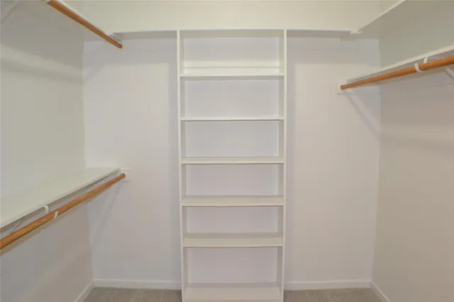 a view of walk in closet with empty racks