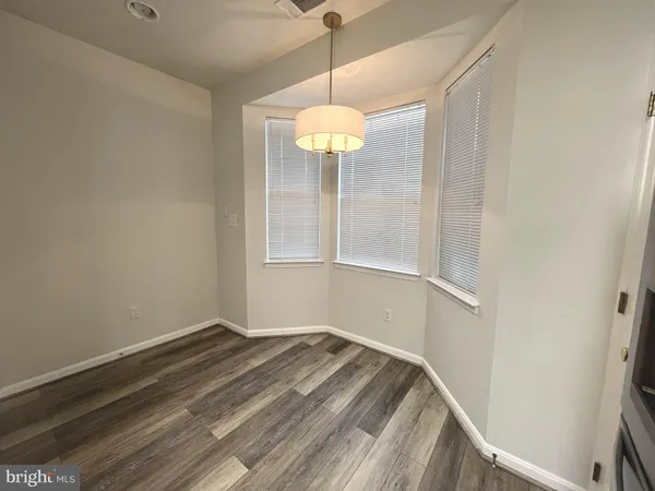 a view of a room with wooden floor and chandelier