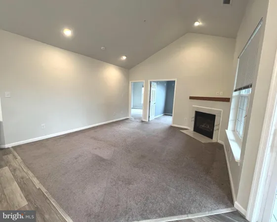 an empty room with wooden floor and fireplace