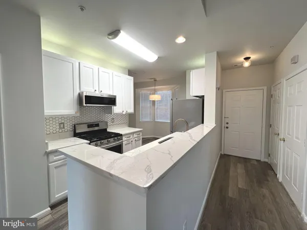 a large white kitchen with cabinets