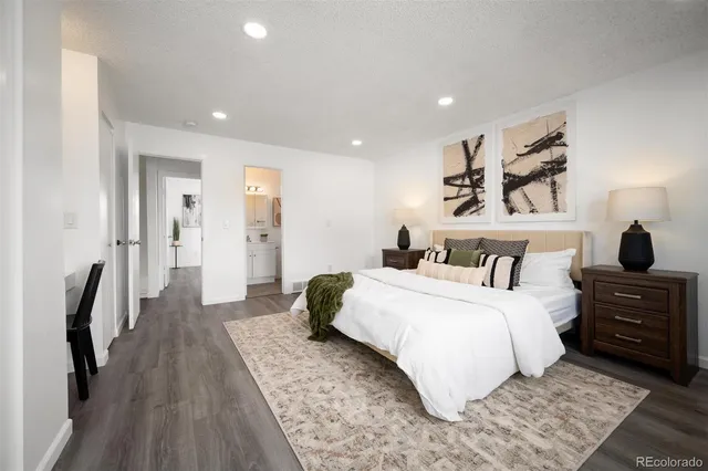 a bedroom with a bed and a painting on the wall