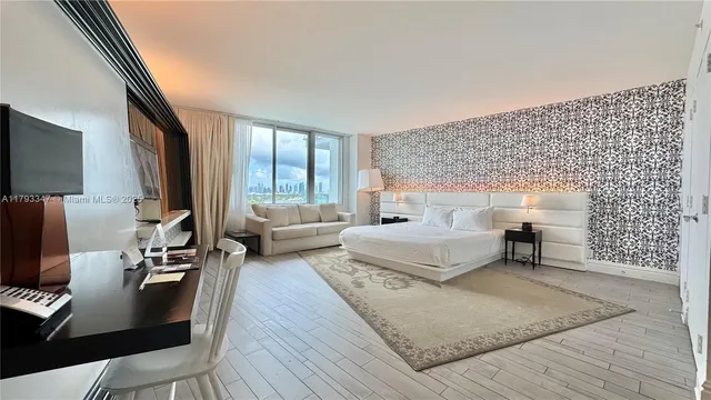 a bedroom with a bed and large windows