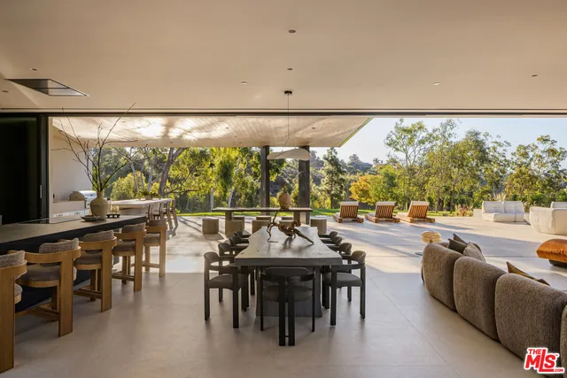 a kitchen with granite countertop a stove a sink a dining table and chairs