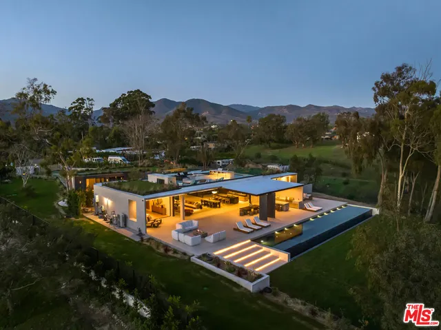 an aerial view of a house with a garden and trees