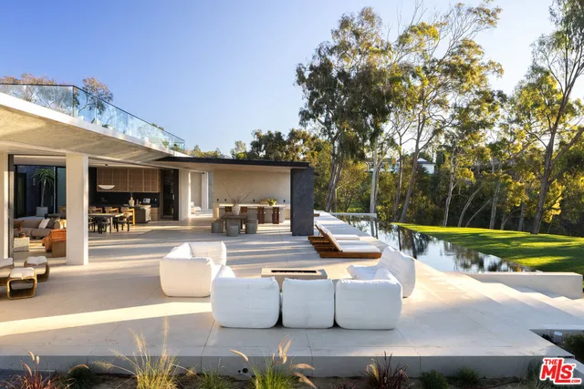 a view of a patio with couches and table and chairs and potted plants