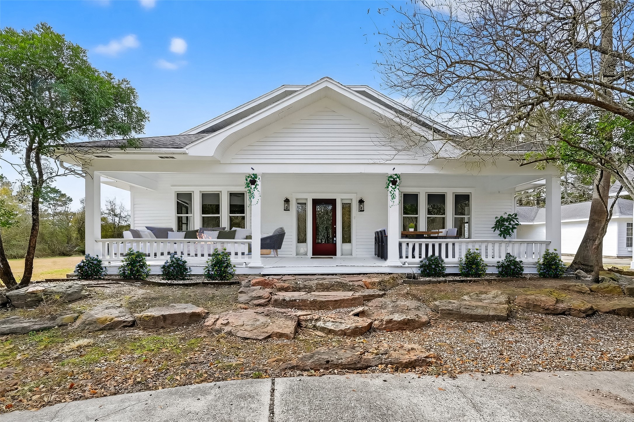 38011 Spur 149 Road Magnolia, TX 77354 - Photo 3 of 50 Charming white house with a spacious porch, surrounded by trees and landscaped with stone steps