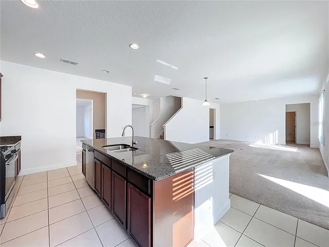a kitchen with stainless steel appliances granite countertop a sink and a stove