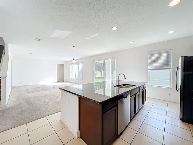a kitchen with a sink refrigerator and cabinets