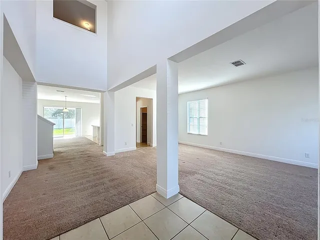 a view of a hallway with wooden floor and a bathroom