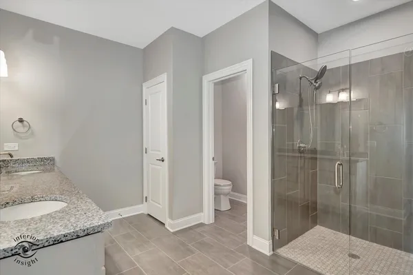 a bathroom with a granite countertop sink a large mirror and a shower