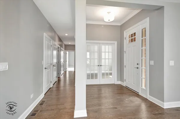 a view of a hallway with wooden floor and windows
