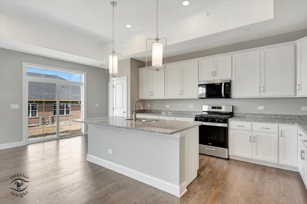 a kitchen with stainless steel appliances granite countertop a sink stove and wooden floor