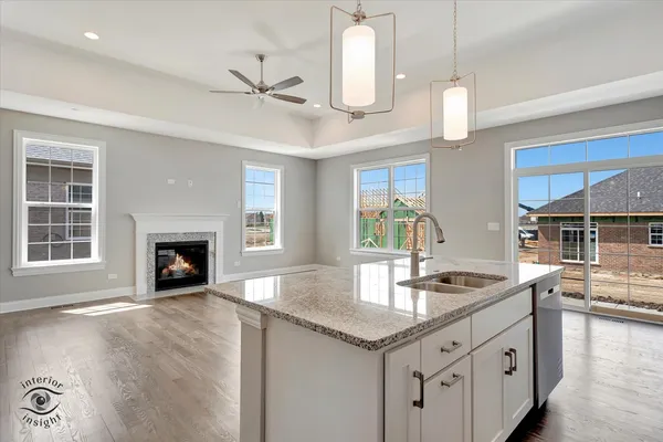 a kitchen with stainless steel appliances granite countertop a sink a stove and a wooden floors
