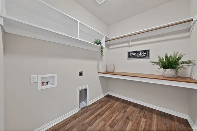 a view of a hallway to a house with wooden floor and a potted plant