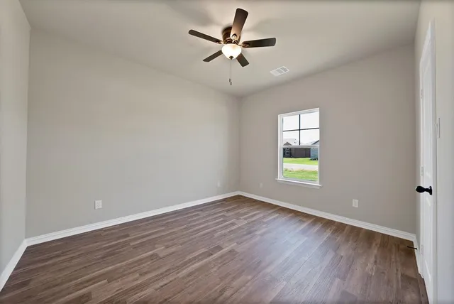 wooden floor in an empty room with a window