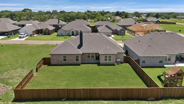 an aerial view of residential houses with outdoor space and pool