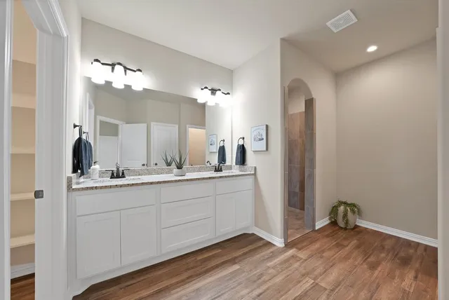 a bathroom with a double vanity sink and a mirror