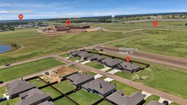 an aerial view of a city with lots of residential buildings ocean and mountain view in back