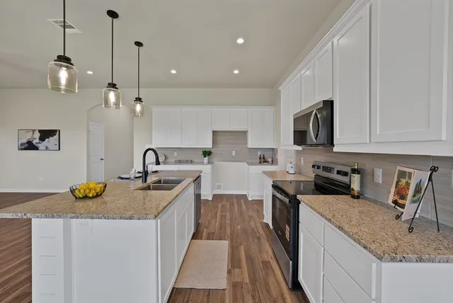 a kitchen with a sink a counter space appliances and cabinets