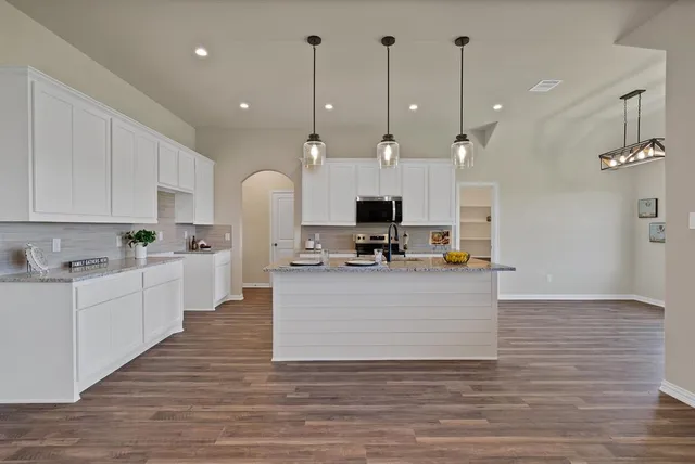 a large white kitchen with cabinets