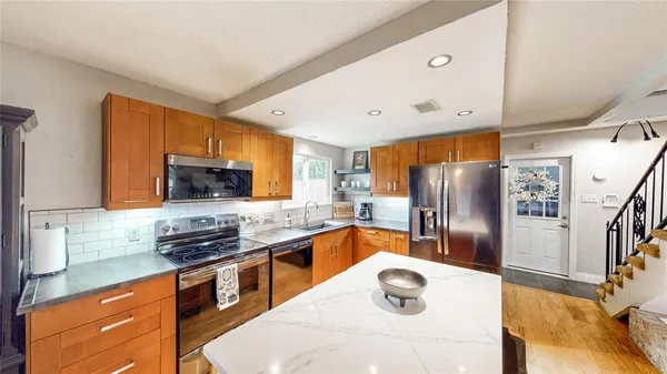 a kitchen with stainless steel appliances a sink stove and refrigerator