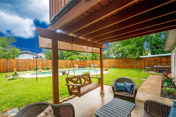 a backyard of a house with fountain table and chairs