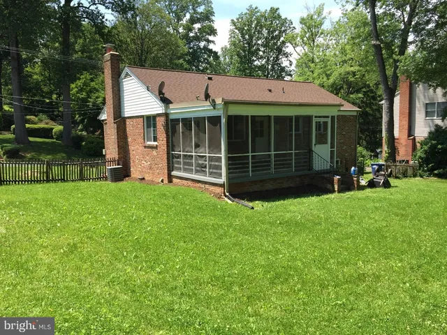 a view of a house with a yard and a large tree