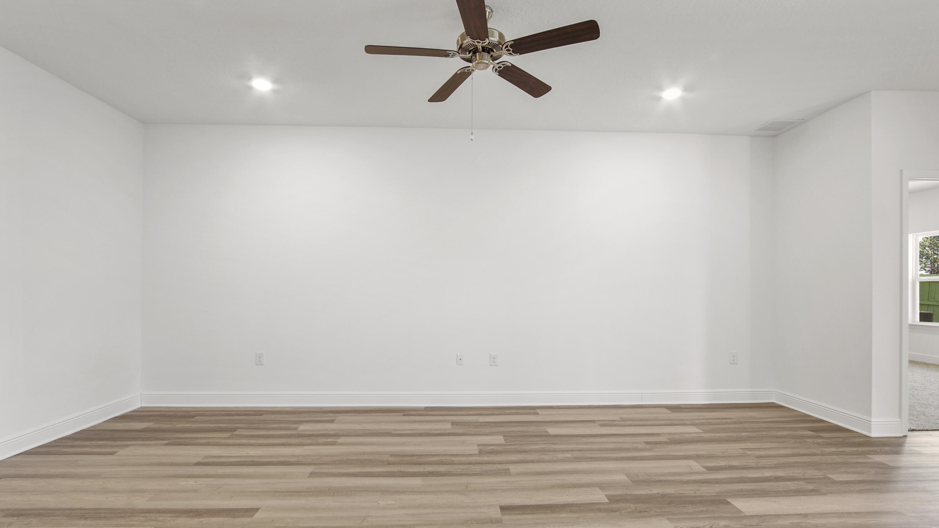 39 Gray Owl Drive Freeport, FL 32439 - Photo 5 of 31 a view of an empty room with wooden floor and a ceiling fan