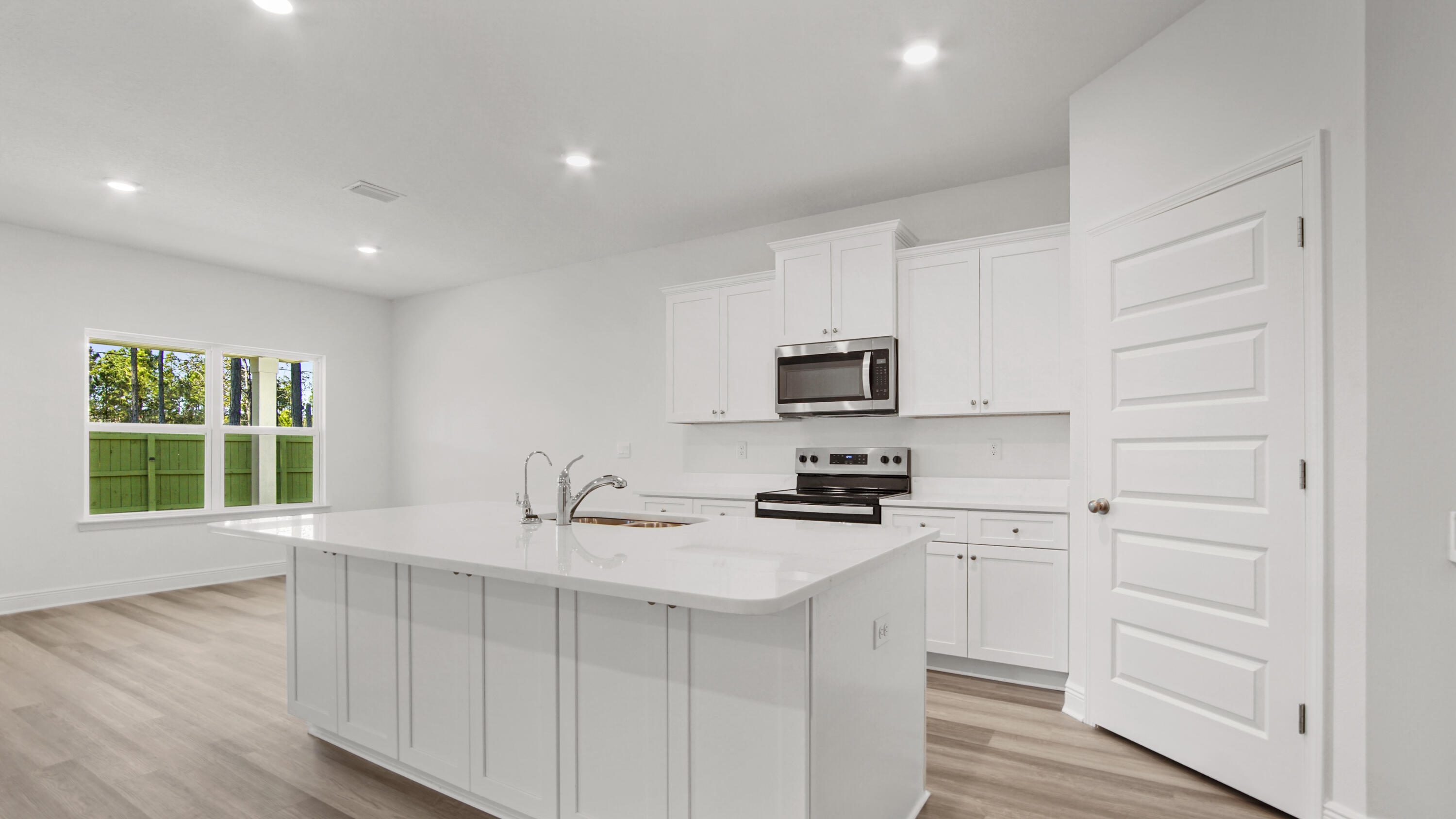 39 Gray Owl Drive Freeport, FL 32439 - Photo 6 of 31 a kitchen with stainless steel appliances white cabinets a stove top oven a sink and dishwasher with wooden floor