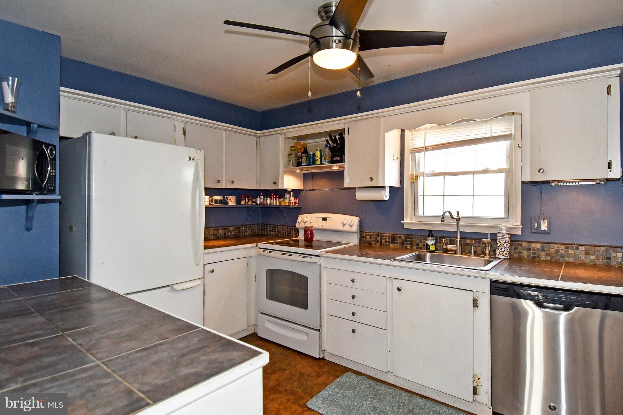 1024 Grovehill Road Baltimore, MD 21227 - Photo 13 of 39 a kitchen with a sink a stove a refrigerator and cabinets