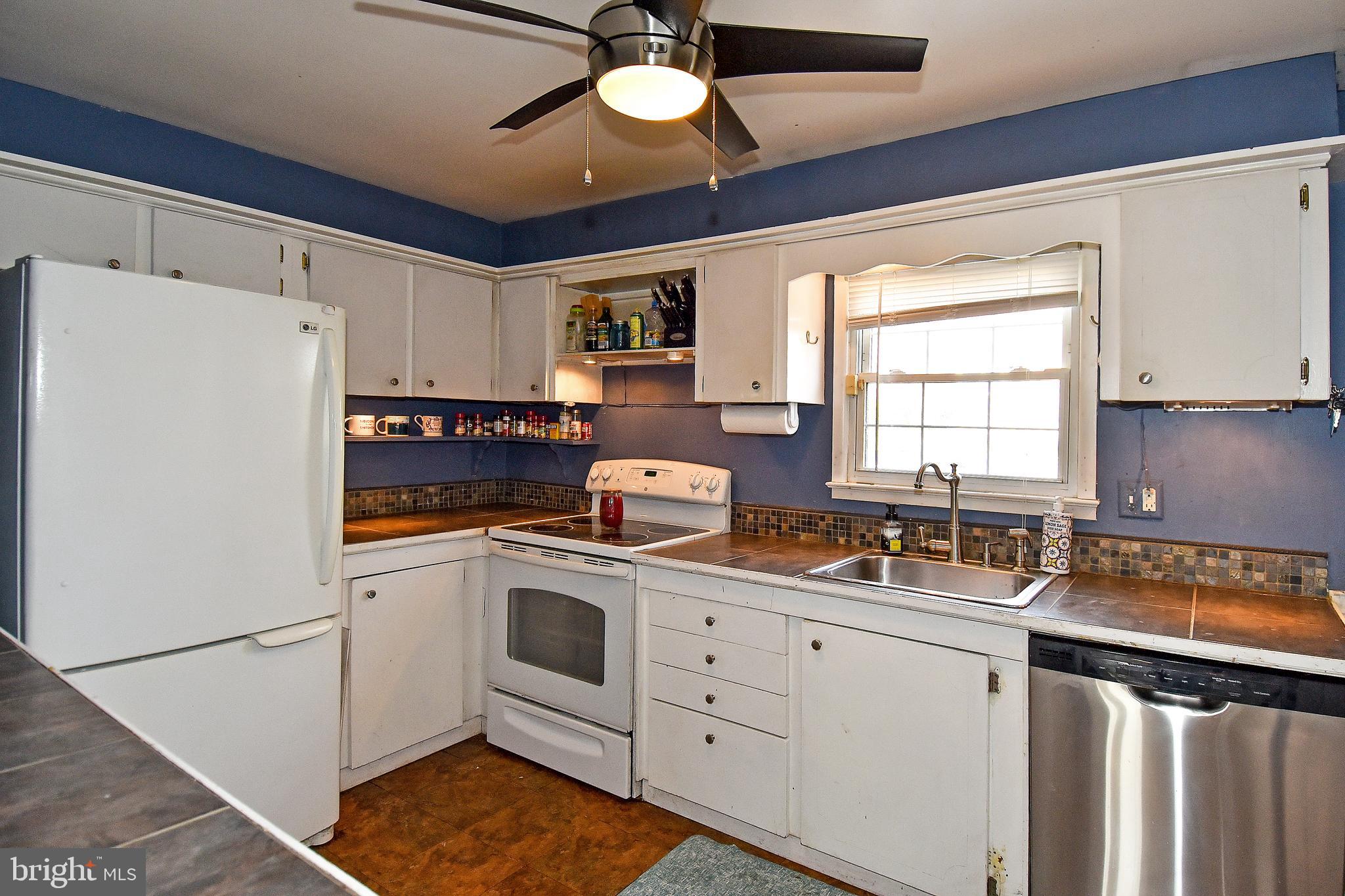1024 Grovehill Road Baltimore, MD 21227 - Photo 14 of 39 a kitchen with a sink cabinets stainless steel appliances and a window