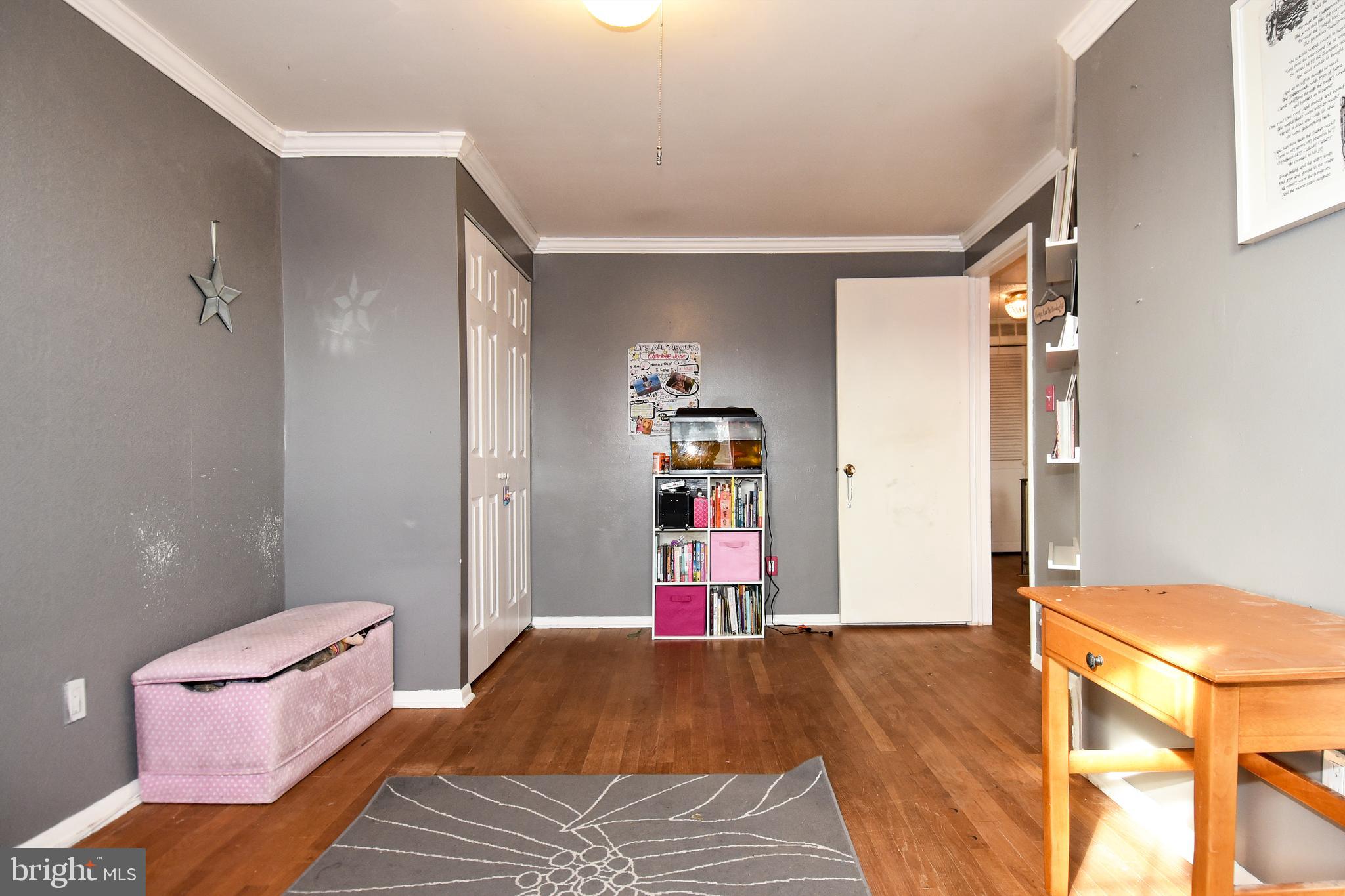 1024 Grovehill Road Baltimore, MD 21227 - Photo 23 of 39 a bedroom with a bed and wooden floor
