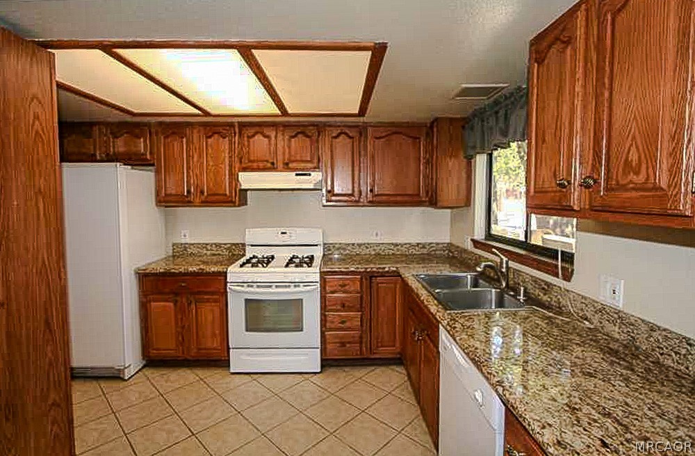 337 Maple Lane Sugarloaf, CA 92386 - Photo 3 of 25 a kitchen with stainless steel appliances granite countertop a stove a sink and a refrigerator