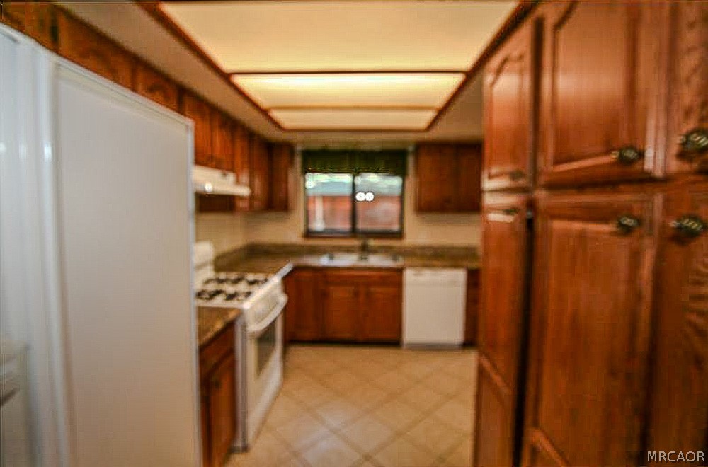 337 Maple Lane Sugarloaf, CA 92386 - Photo 4 of 25 a kitchen with stainless steel appliances granite countertop a stove a sink and a refrigerator