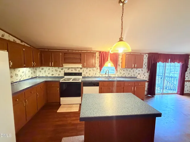 a kitchen with stainless steel appliances granite countertop wooden cabinets a stove and a sink