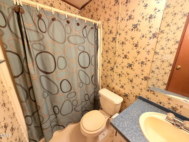 a bathroom with a granite countertop toilet and a sink