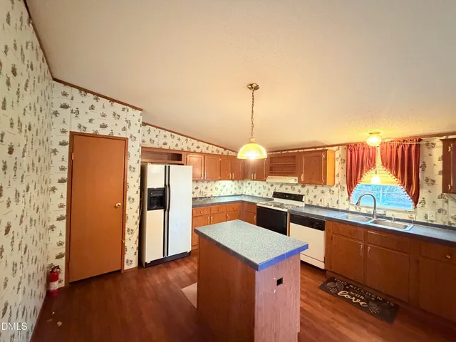 a kitchen with stainless steel appliances granite countertop a sink and a refrigerator