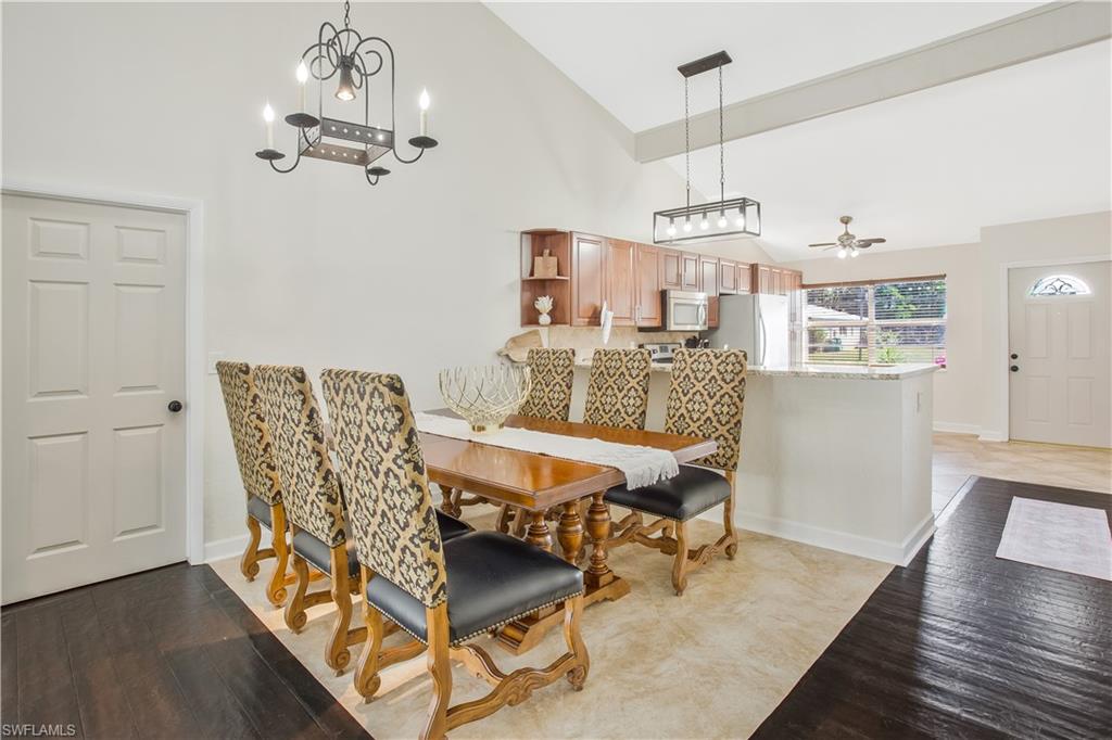 1039 Cardinal Street Naples, FL 34104 - Photo 11 of 29 a dining room with furniture a chandelier and wooden floor