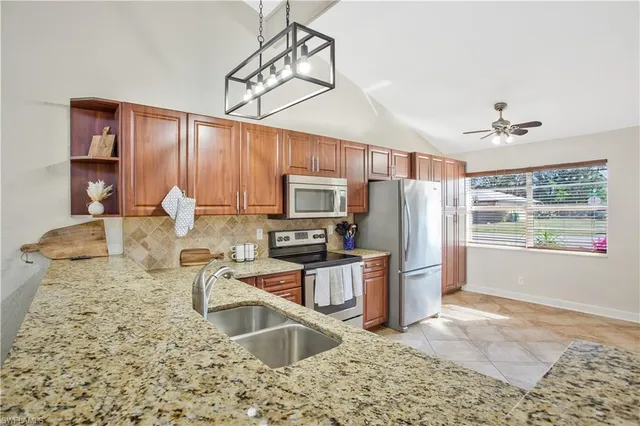 a kitchen with granite countertop a refrigerator and a sink