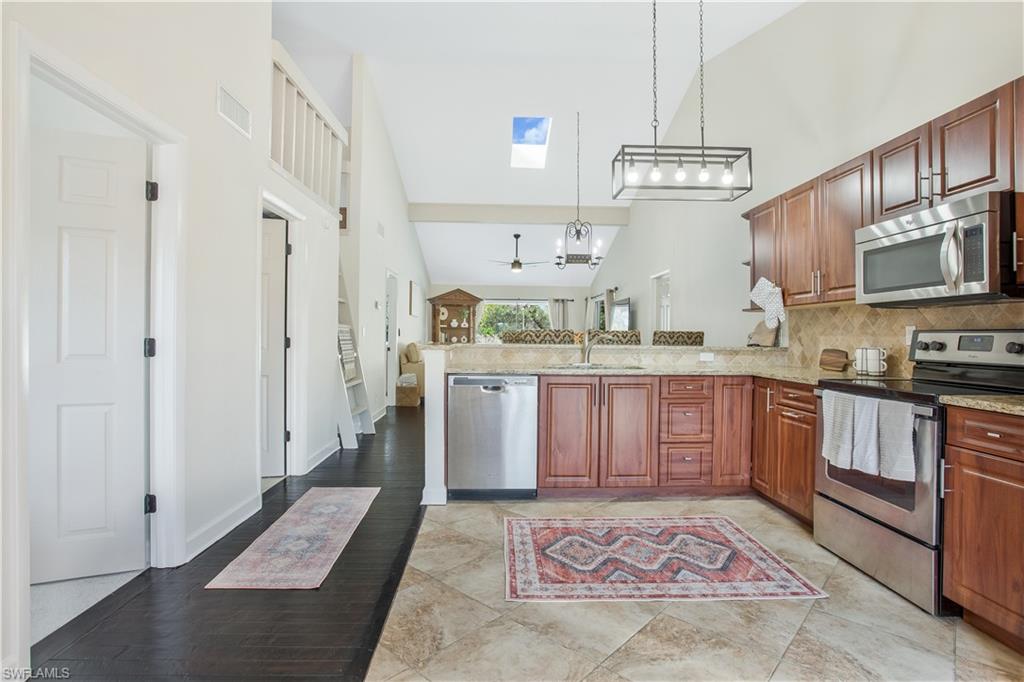 1039 Cardinal Street Naples, FL 34104 - Photo 14 of 29 a kitchen with stainless steel appliances granite countertop a sink stove and refrigerator